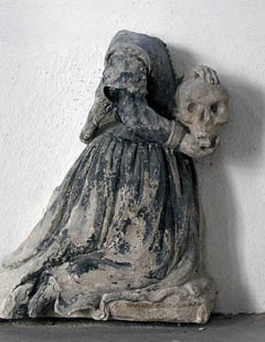 a fragment of a monument in Horseheath - the skull means that she had pre-deceased her parents...